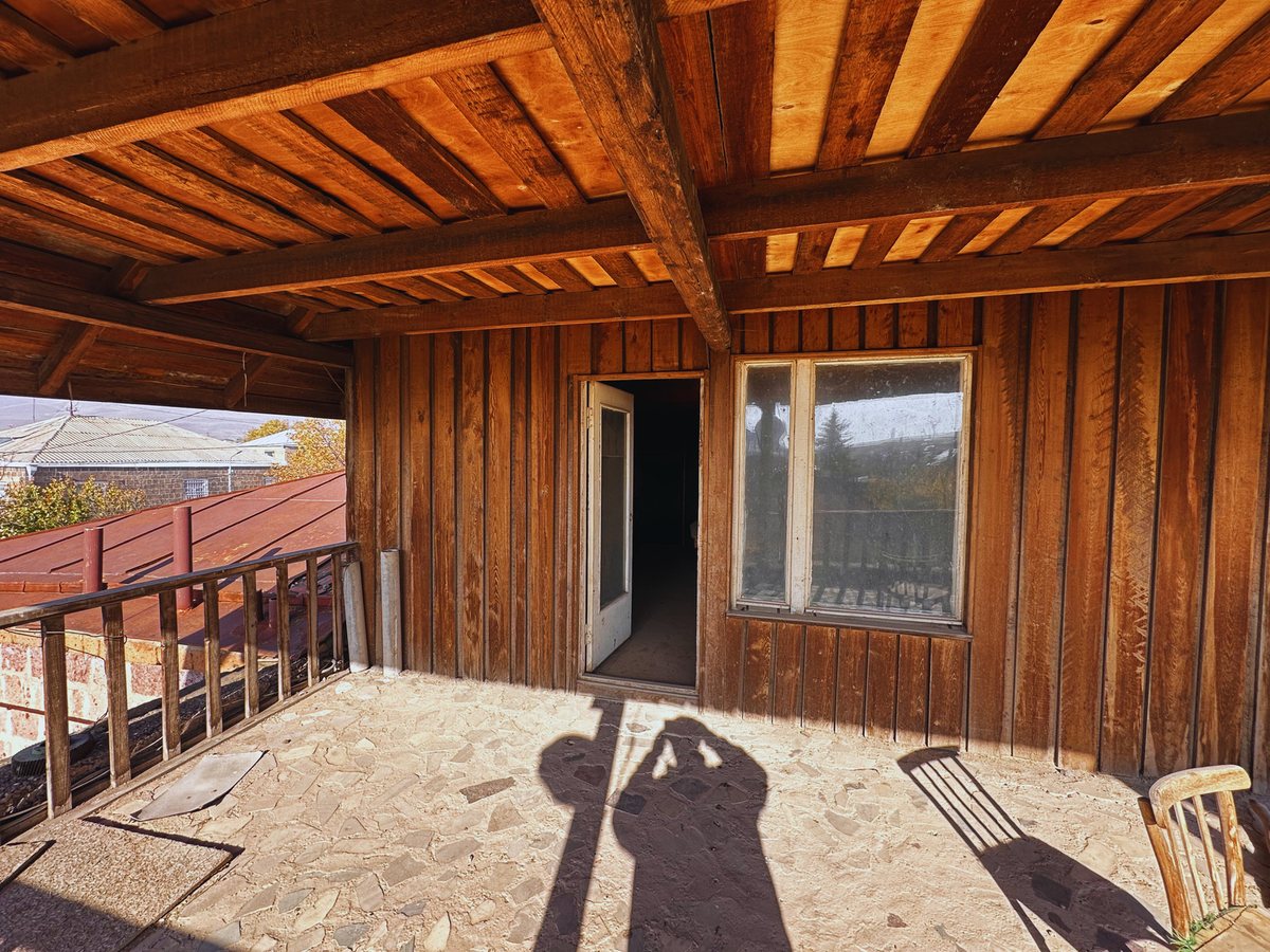 Open attic balcony with wooden railing, current condition