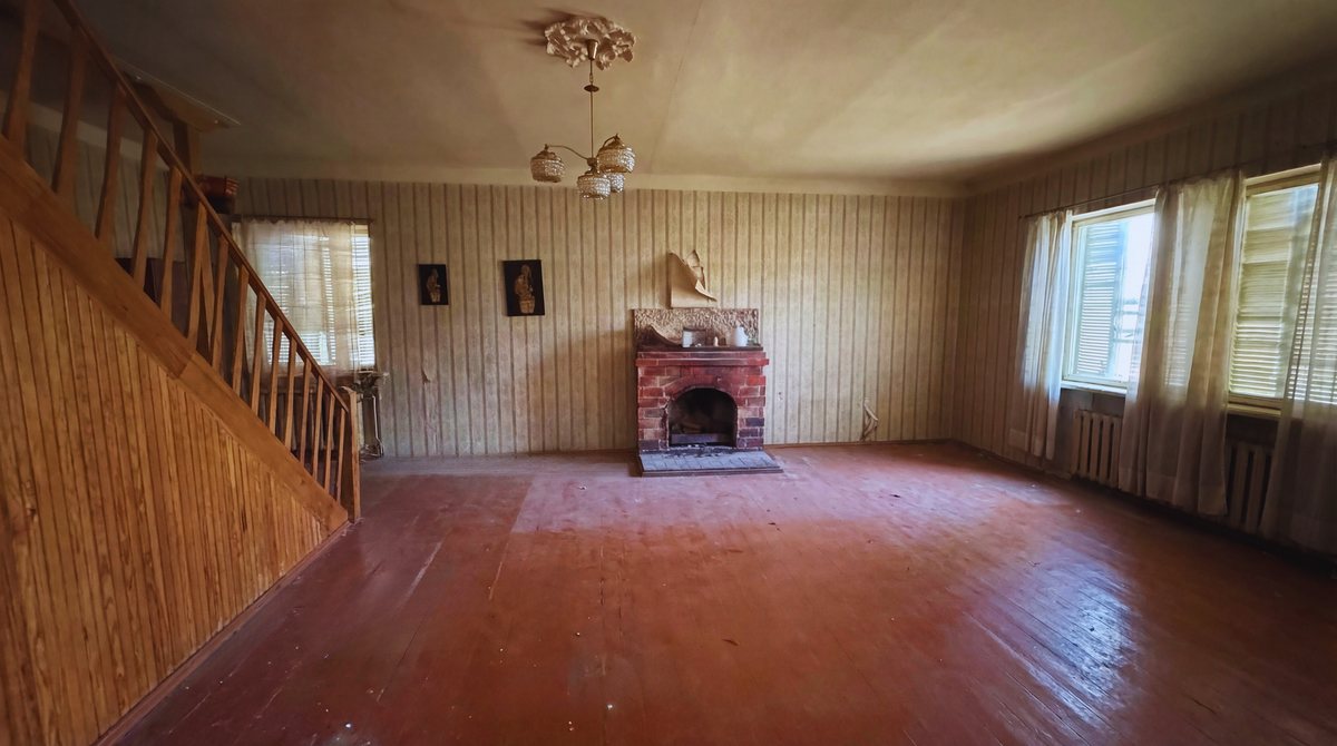 Living space with fireplace on the main residential floor, current condition